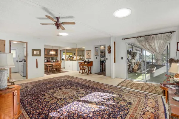 a living room with a couch and a dining table with wooden floor