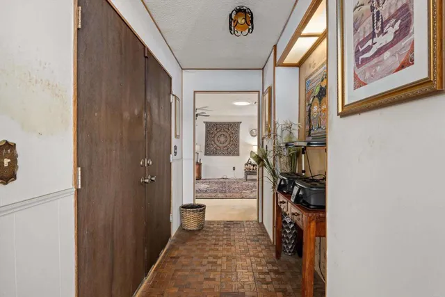 a view of a hallway with a livingroom and a bathroom