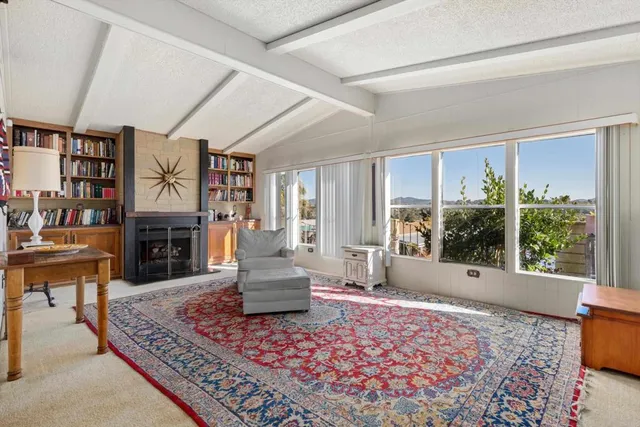 a living room with furniture large window and a fireplace