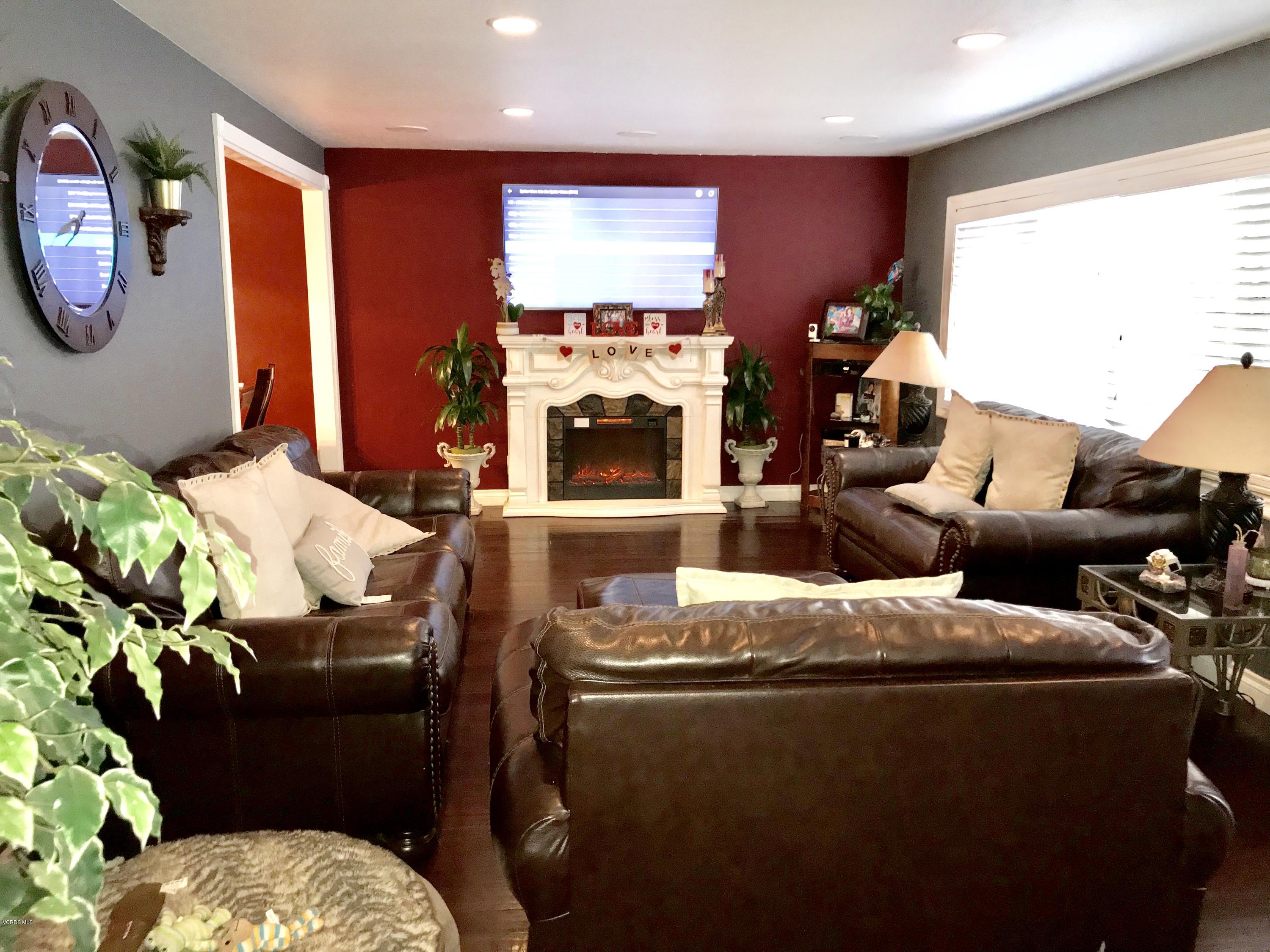 4010 South J Street Oxnard, CA 93033 - Photo 3 of 18 a living room with furniture a large window and a fireplace