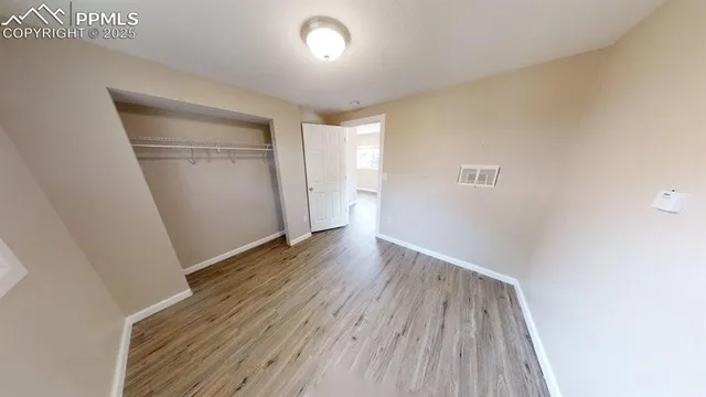 an empty room with wooden floor and entrance