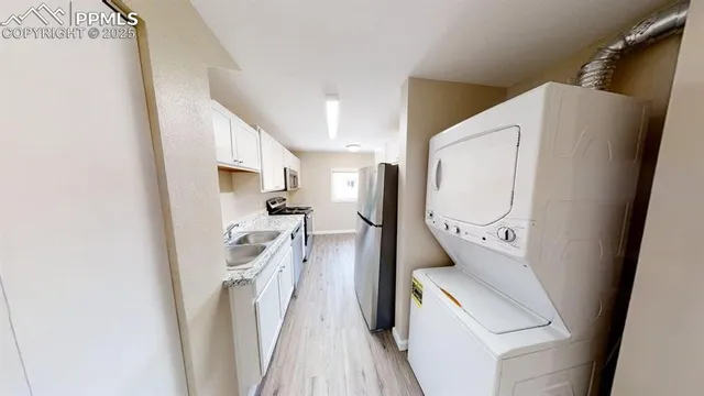a utility room with wooden floor washer and dryer