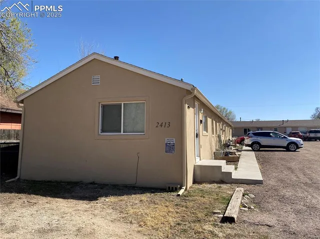 a backyard of a house with table and chairs