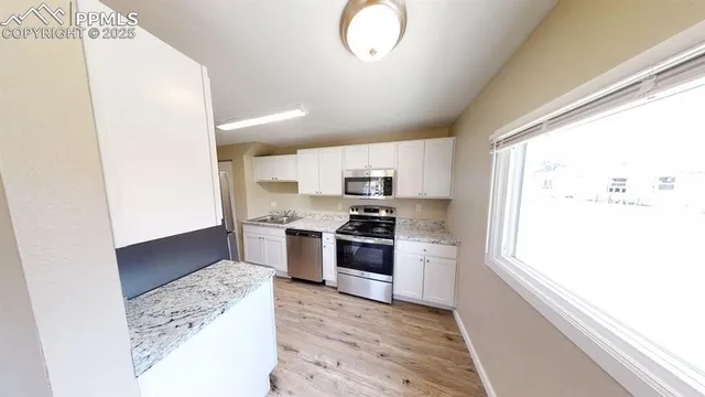 a kitchen with stainless steel appliances granite countertop a stove a sink and a microwave