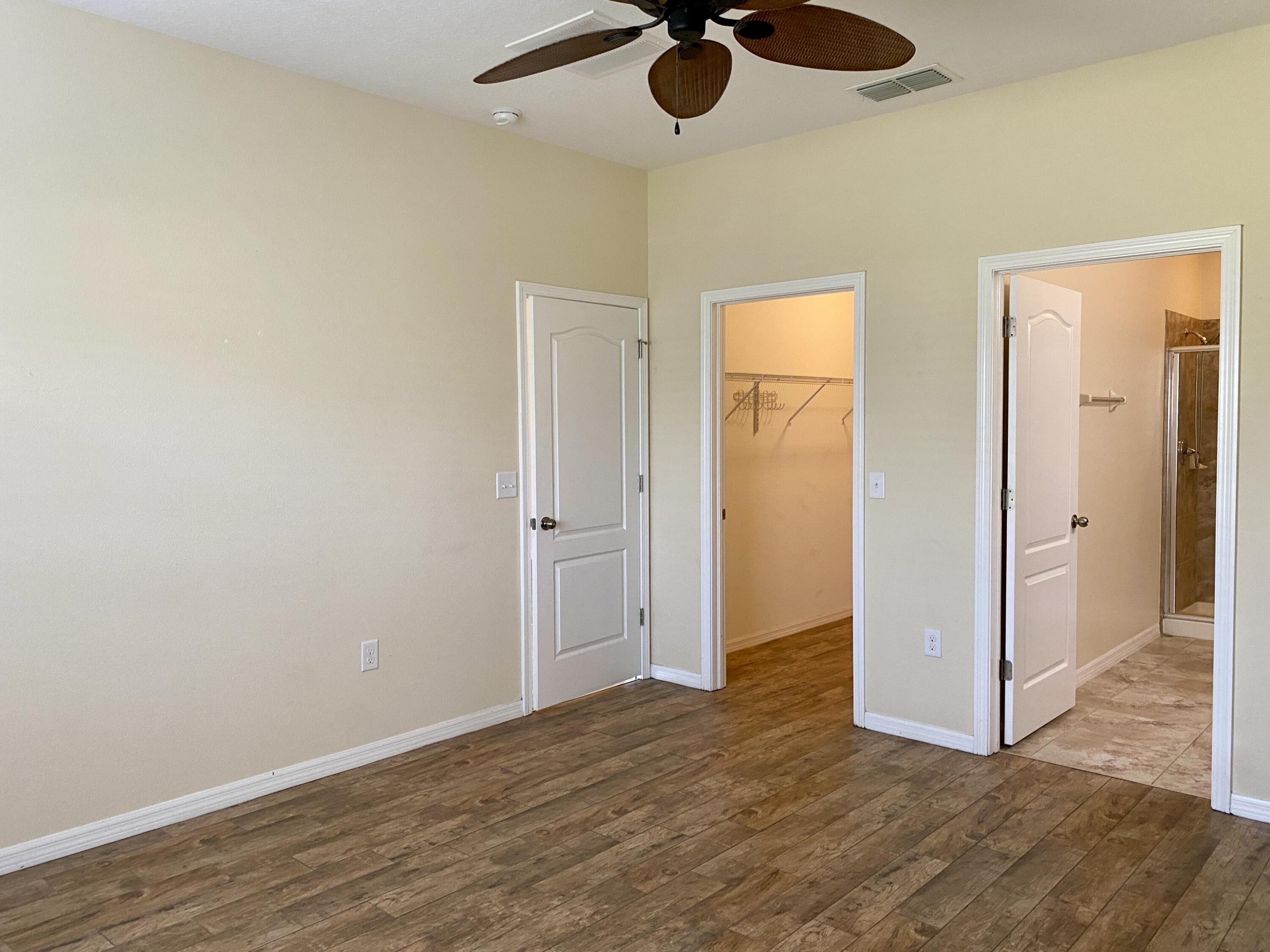 3490 Funston Circle Melbourne, FL 32940 - Photo 11 of 25 an empty room with wooden floor cabinet and a ceiling fan