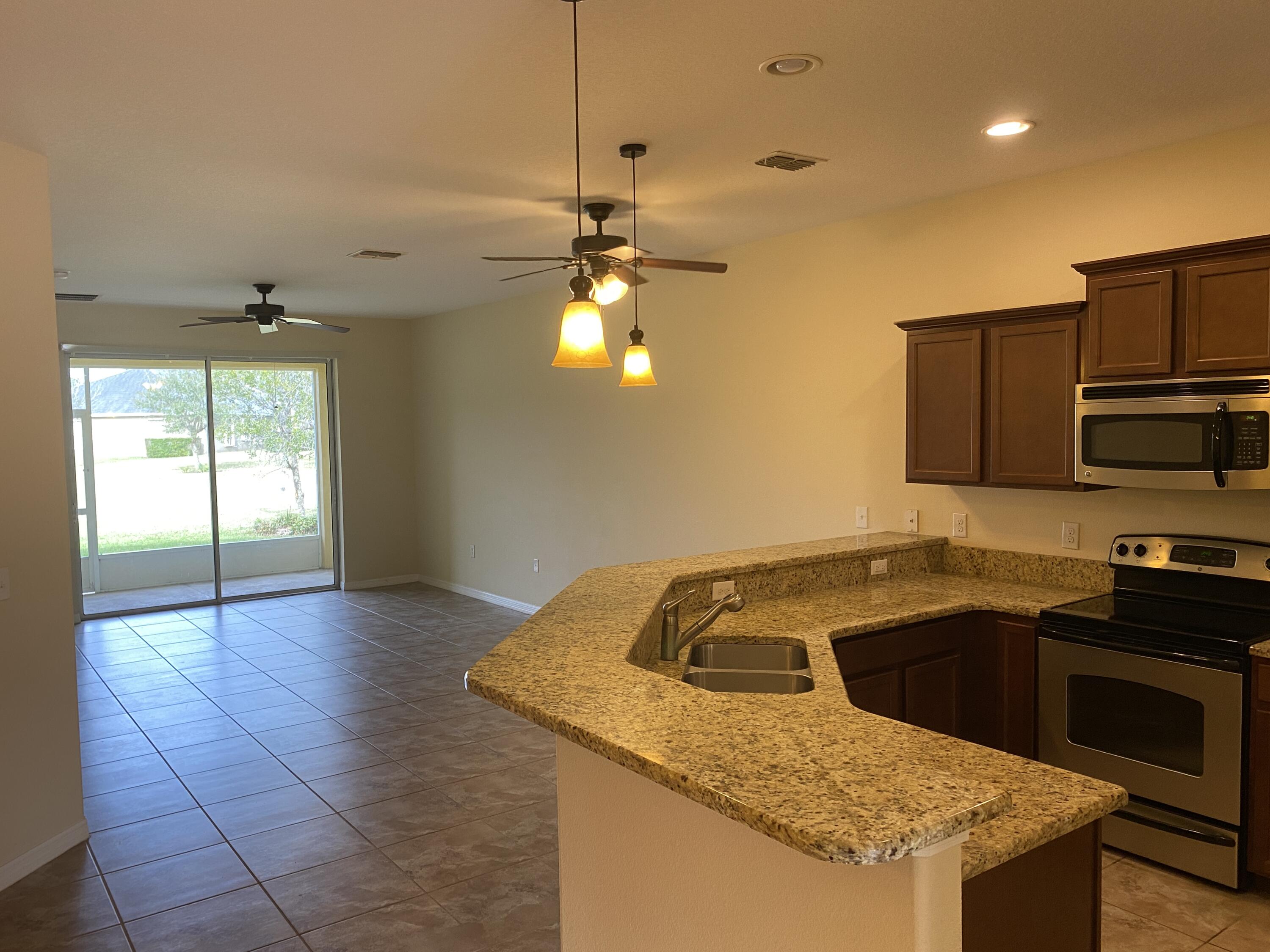 3490 Funston Circle Melbourne, FL 32940 - Photo 7 of 25 a kitchen that has a sink a stove and a microwave