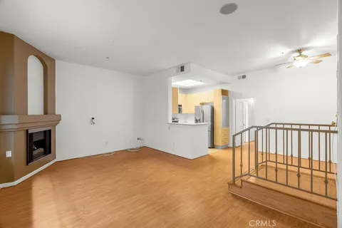 a view of a livingroom with wooden floor and a fireplace