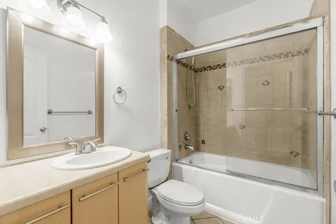 a bathroom with a granite countertop sink a toilet and shower