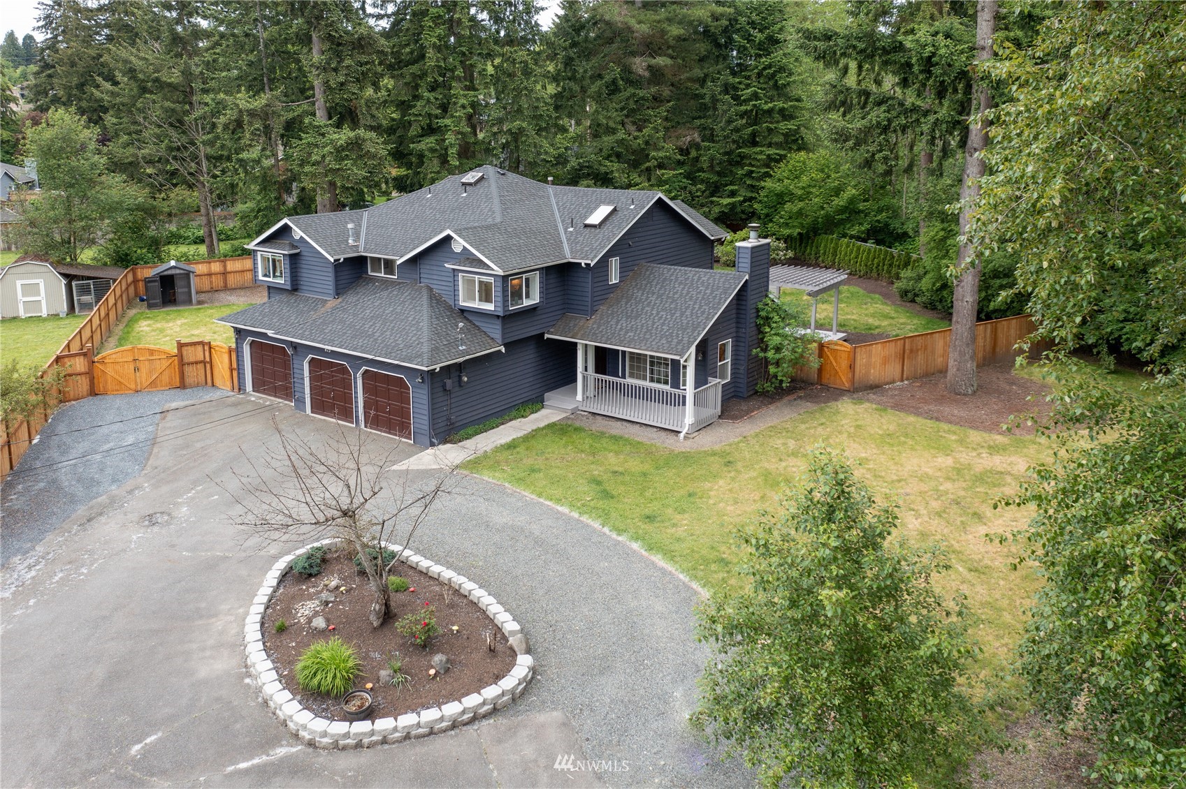 415 170th Place Southwest Bothell, WA 98012 - Photo 3 of 36 an aerial view of a house with swimming pool and trees in the background