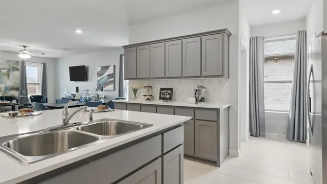 a kitchen with stainless steel appliances a stove a sink a microwave a refrigerator and cabinets