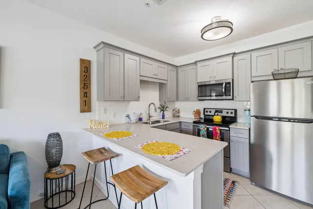 a kitchen with a refrigerator a stove a sink dishwasher and wooden cabinets with wooden floor