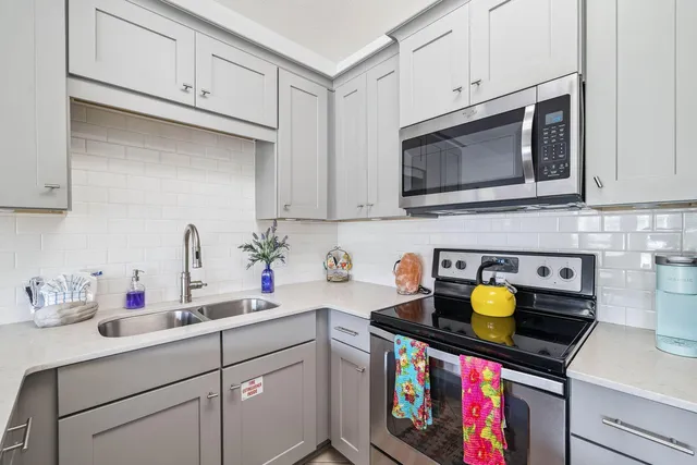 a kitchen with a sink a stove and cabinets
