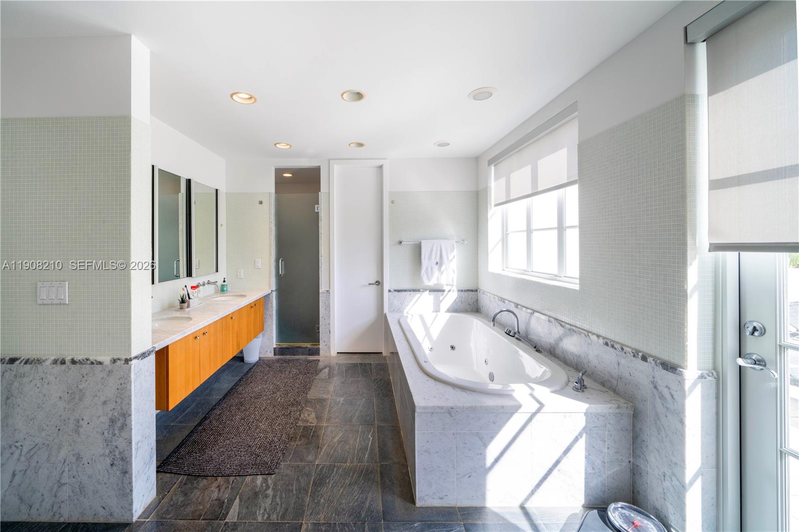 230 Water Way Miami Beach, FL 33141 - Photo 17 of 42 a large bathroom with a granite countertop double vanity sink a mirror and a bathtub