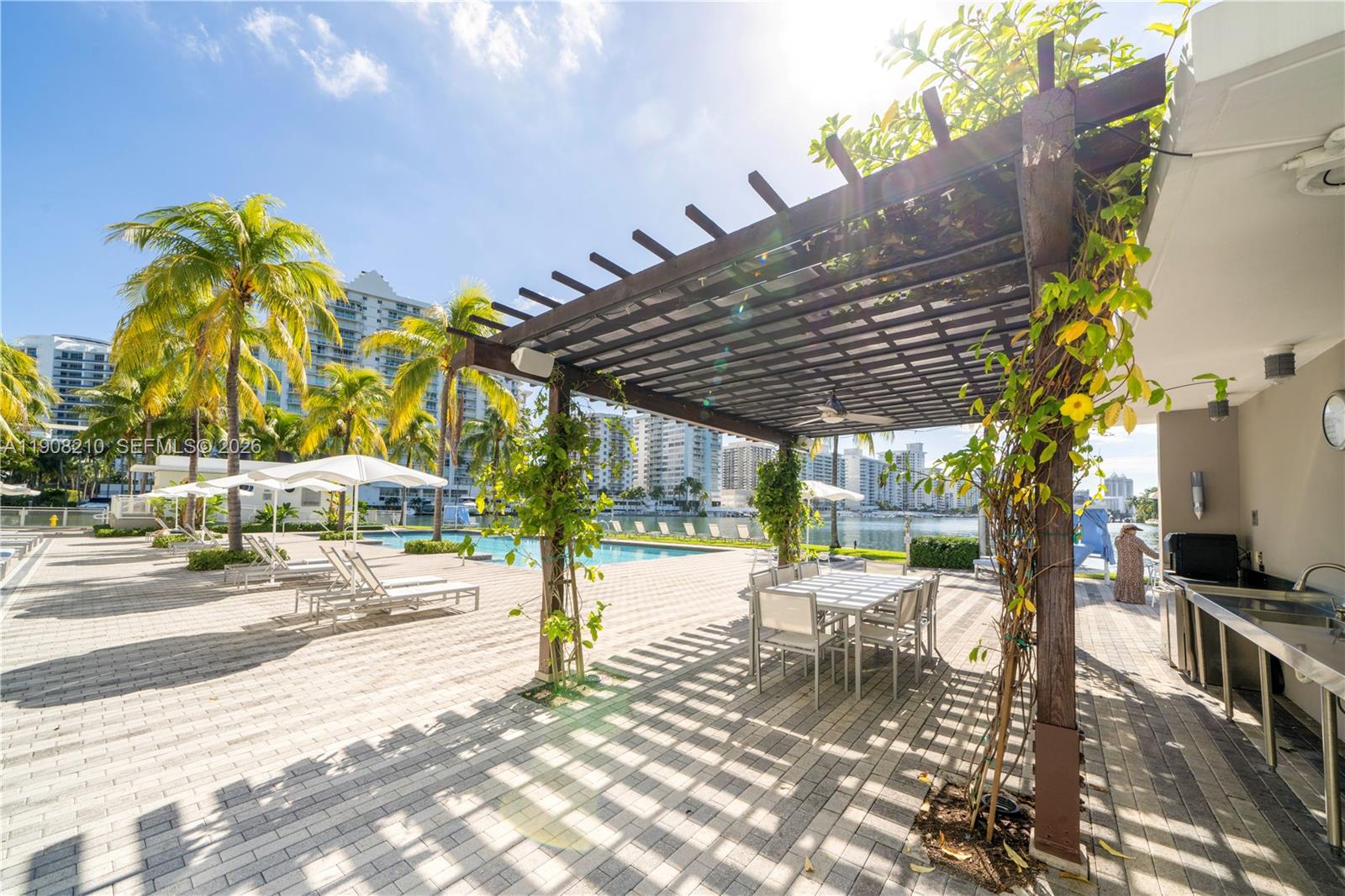 230 Water Way Miami Beach, FL 33141 - Photo 32 of 42 a view of a patio with a table and chairs under an umbrella with a patio