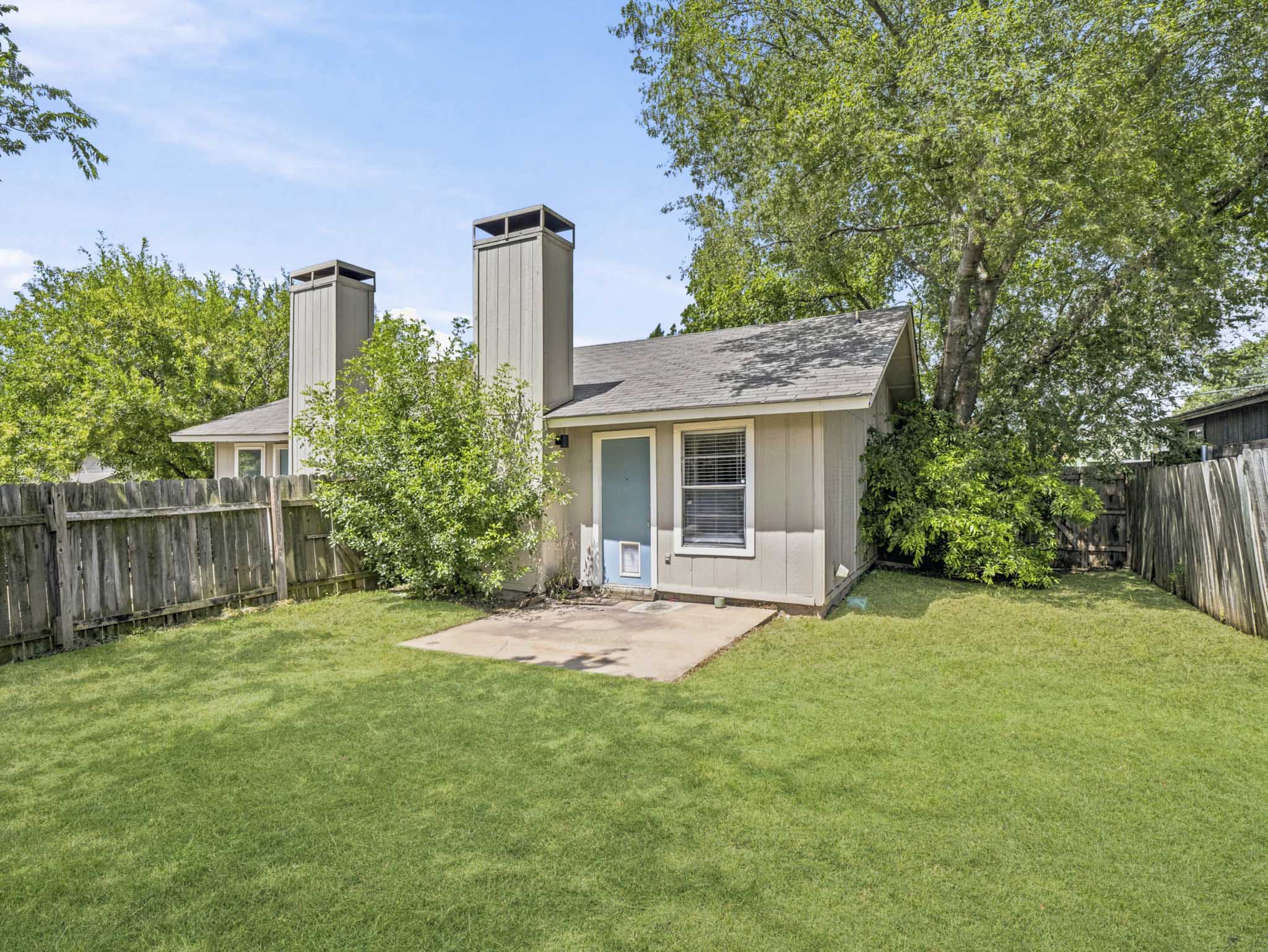 2401 Burleson Road Austin, TX 78741 - Photo 11 of 25 A well-maintained lawn and sturdy wood fencing define this backyard retreat.