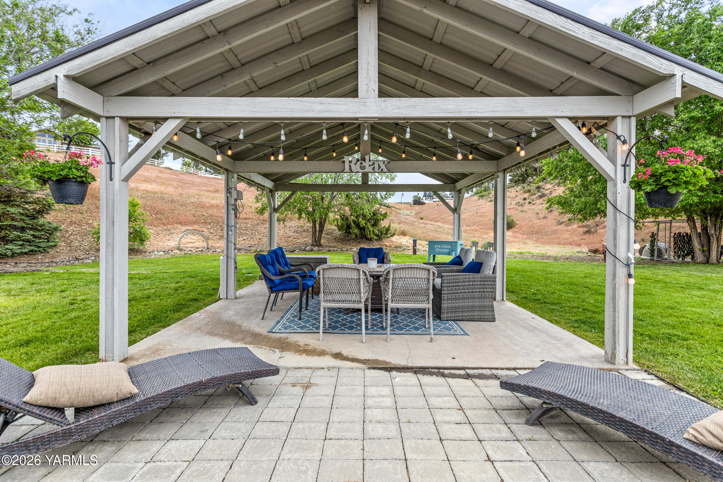 2121 Pleasant Hill Road Selah, WA 98942 - Photo 34 of 38 a view of a patio with table and chairs under an umbrella with a small yard