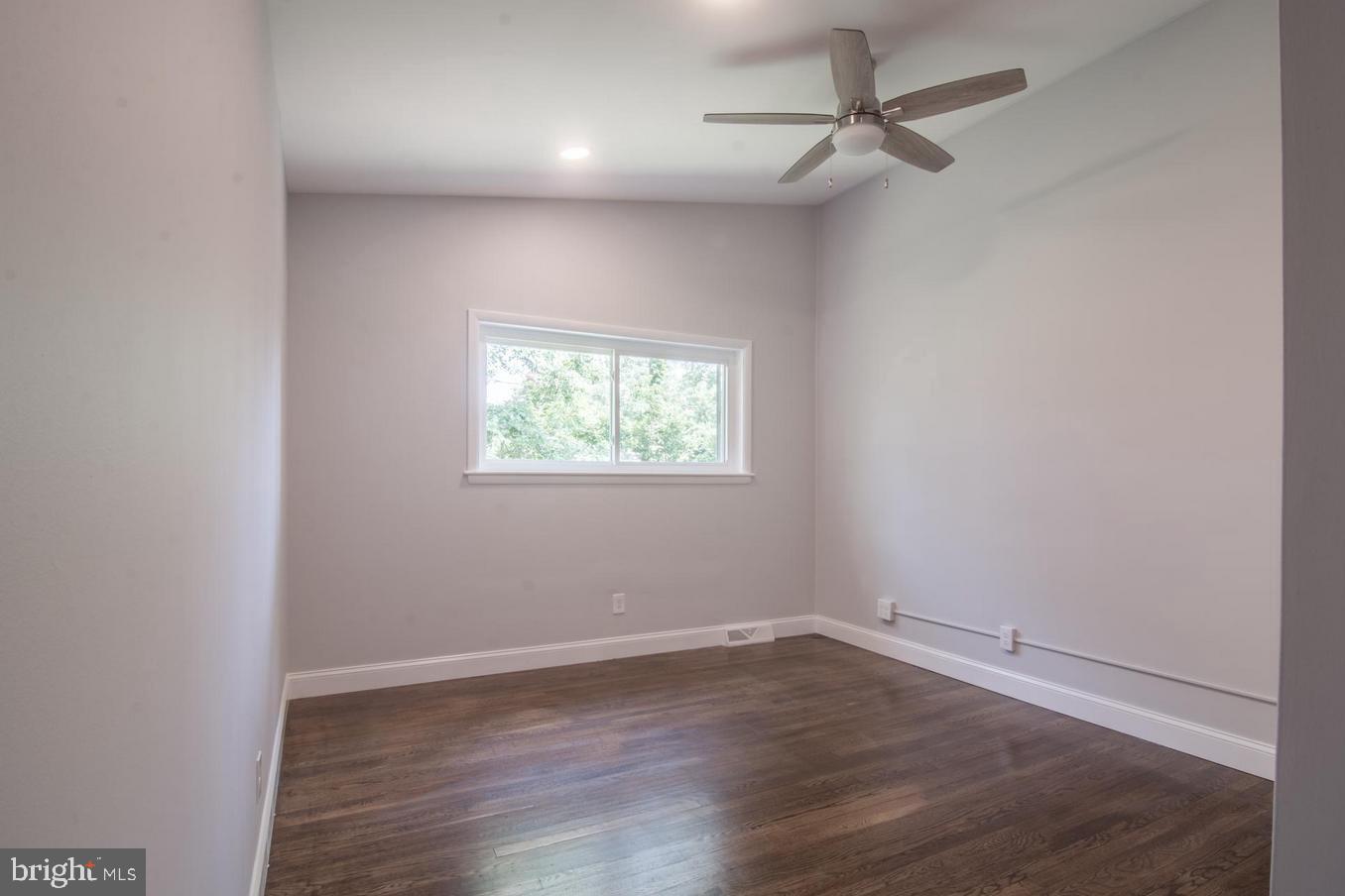 2436 Smith Avenue Baltimore, MD 21209 - Photo 6 of 14 an empty room with wooden floor ceiling fan and windows