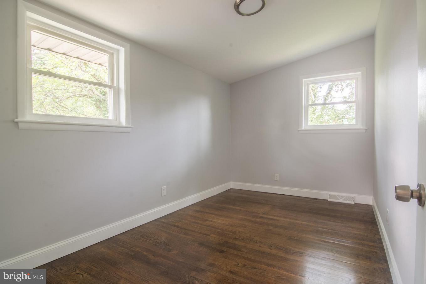 2436 Smith Avenue Baltimore, MD 21209 - Photo 7 of 14 an empty room with wooden floor and windows