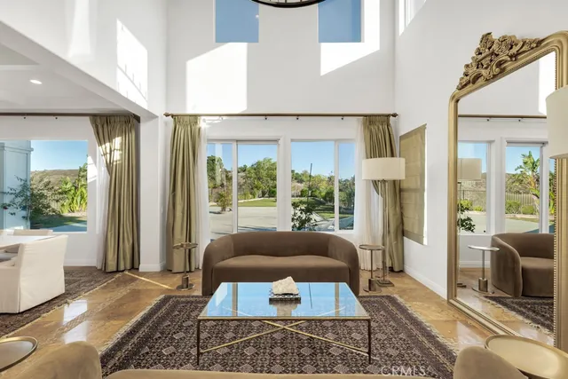 a living room with furniture a flat screen tv and a large window