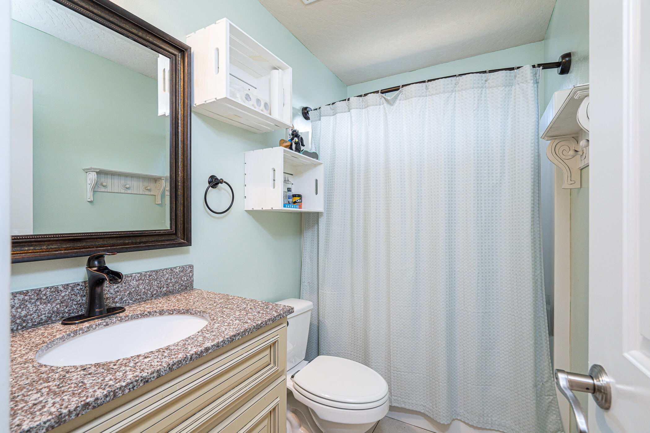 5269 Moore Loop Crestview, FL 32536 - Photo 25 of 36 a bathroom with a granite countertop sink toilet a mirror and shower curtain