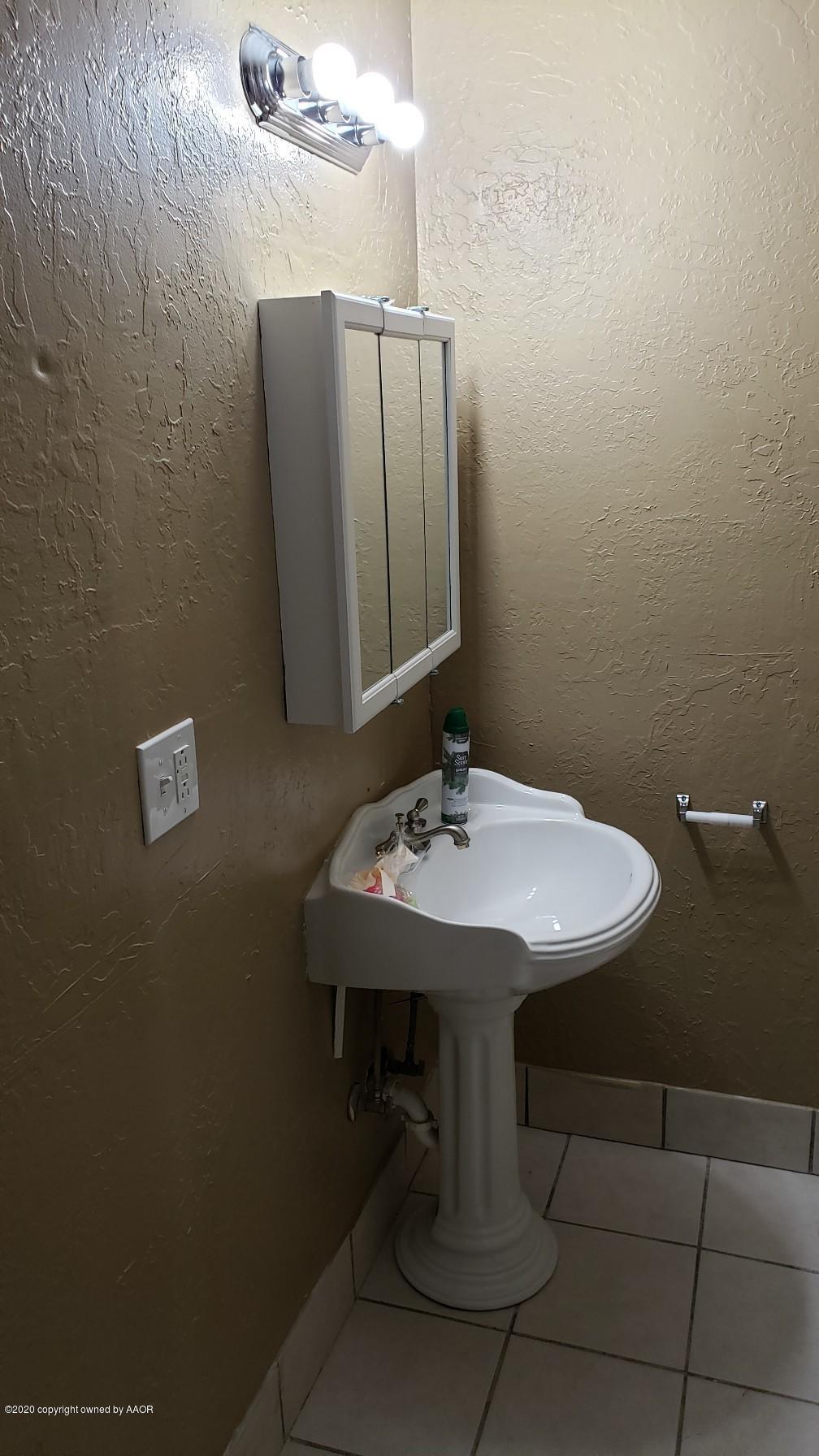 4408 South Ong Street Amarillo, TX 79110 - Photo 14 of 23 a bathroom with a sink a mirror and toilet