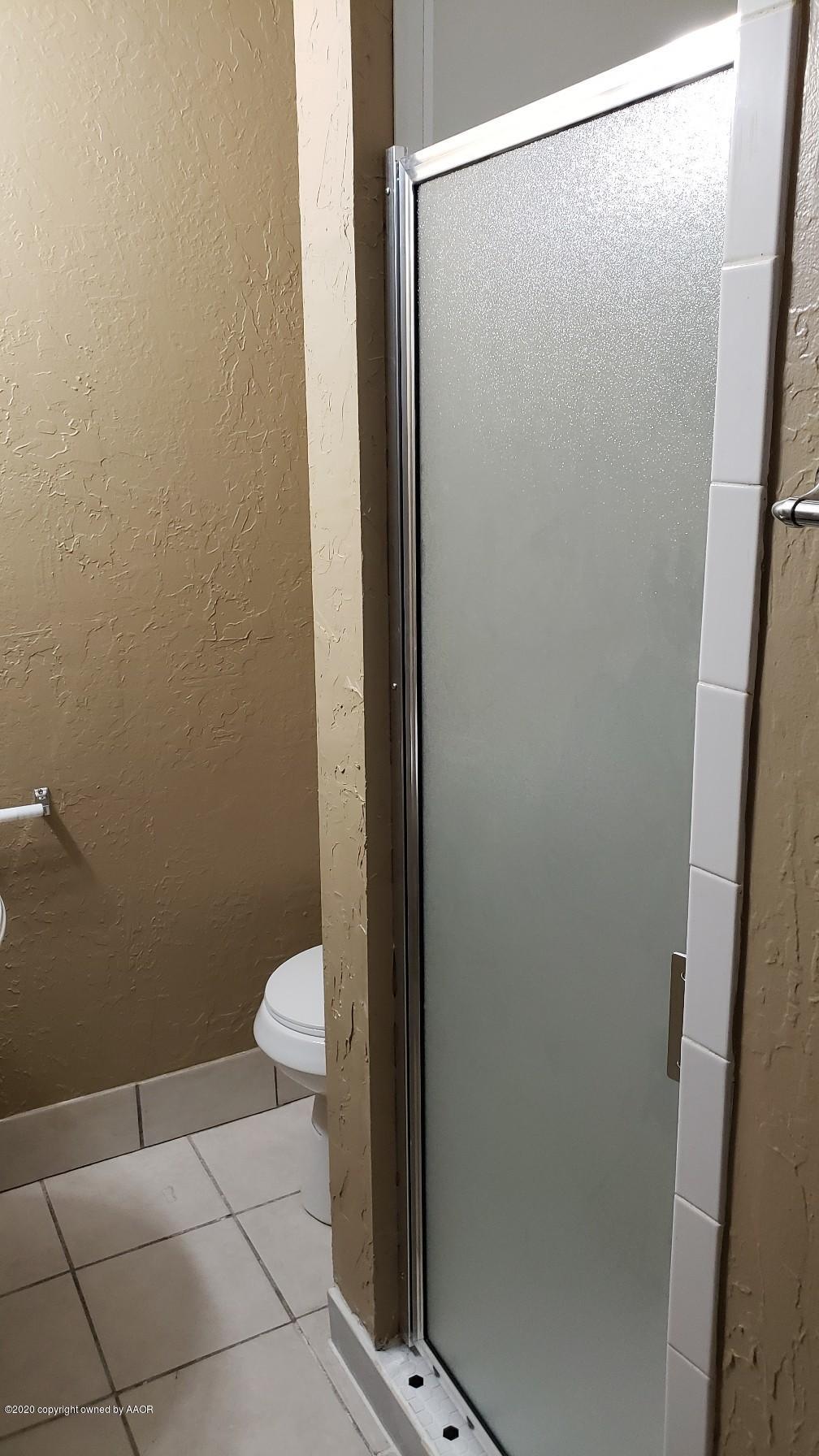 4408 South Ong Street Amarillo, TX 79110 - Photo 15 of 23 a bathroom with a granite countertop shower and a toilet