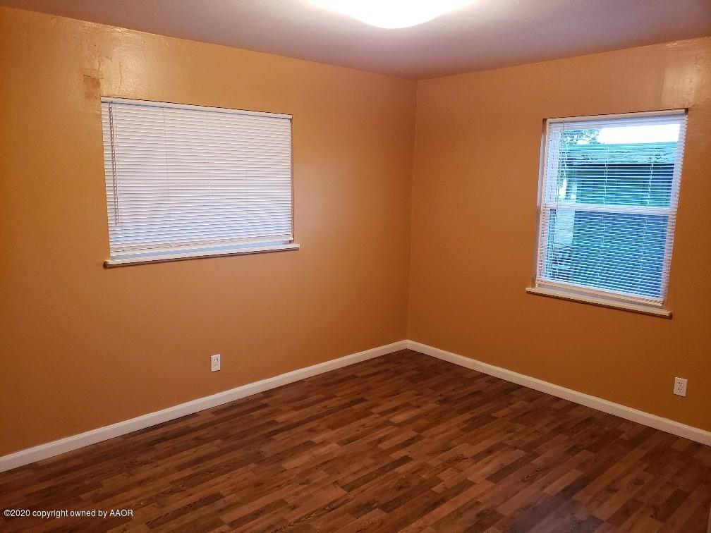 4408 South Ong Street Amarillo, TX 79110 - Photo 17 of 23 a view of an empty room with wooden floor and a window