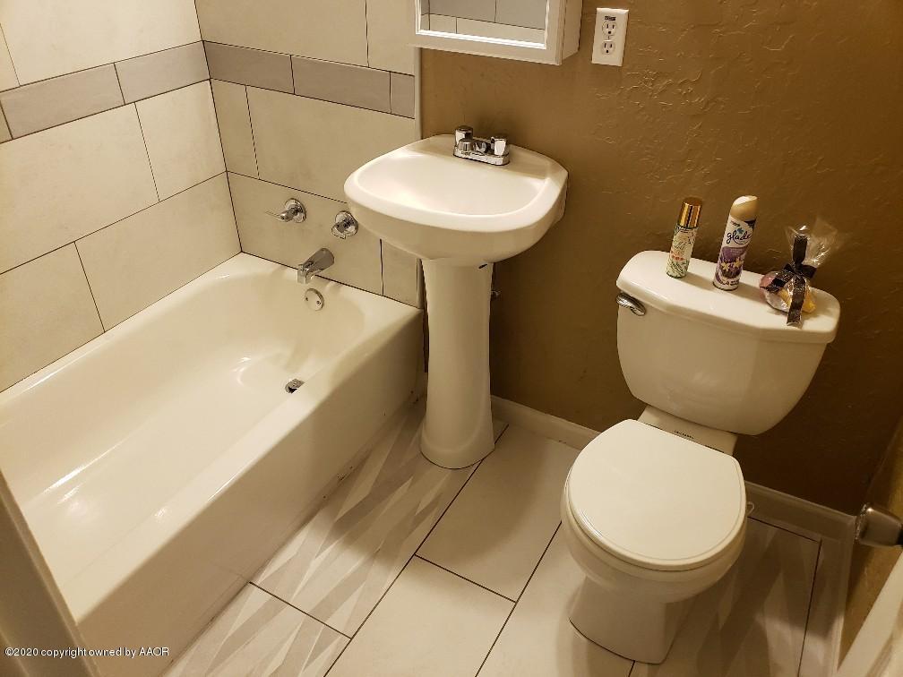 4408 South Ong Street Amarillo, TX 79110 - Photo 19 of 23 a bathroom with a sink mirror and toilet