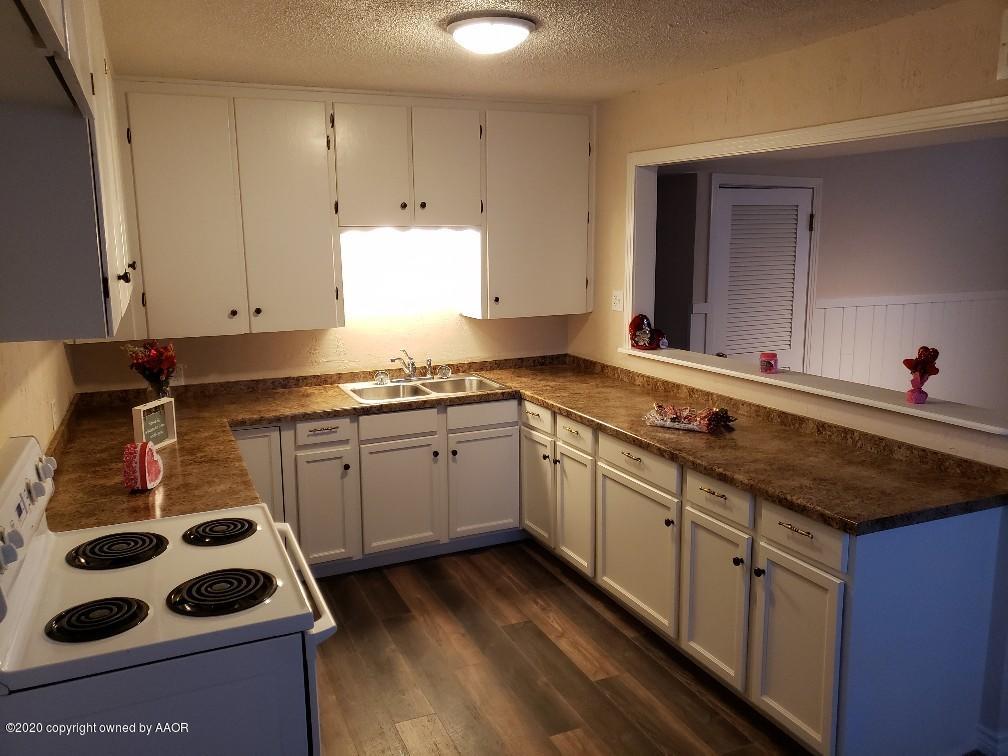 4408 South Ong Street Amarillo, TX 79110 - Photo 5 of 23 a kitchen with granite countertop a sink stove and cabinets