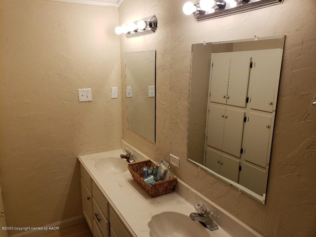 4408 South Ong Street Amarillo, TX 79110 - Photo 10 of 23 a bathroom with a sink and a mirror