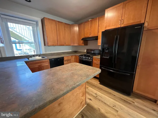a kitchen with granite countertop a refrigerator stove and sink