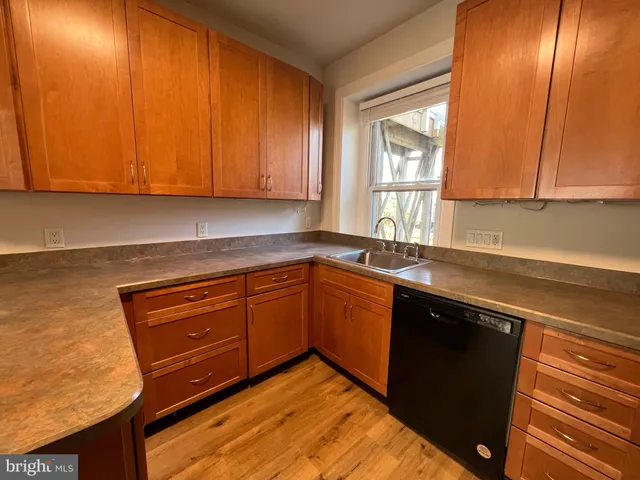 a kitchen with granite countertop cabinets stainless steel appliances a sink and a window