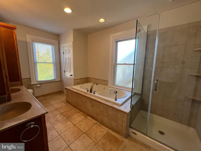 a bathroom with a tub sink and mirror