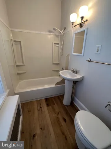 a bathroom with a sink a toilet a mirror and shower