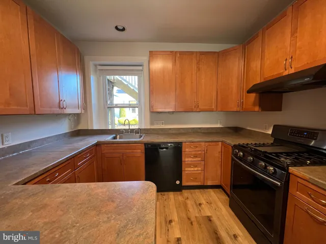 a kitchen with granite countertop wooden cabinets and a stove top oven