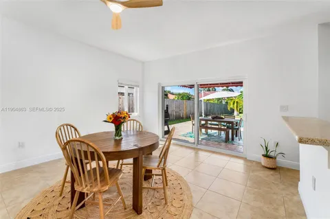 a dining room with furniture and a potted plant