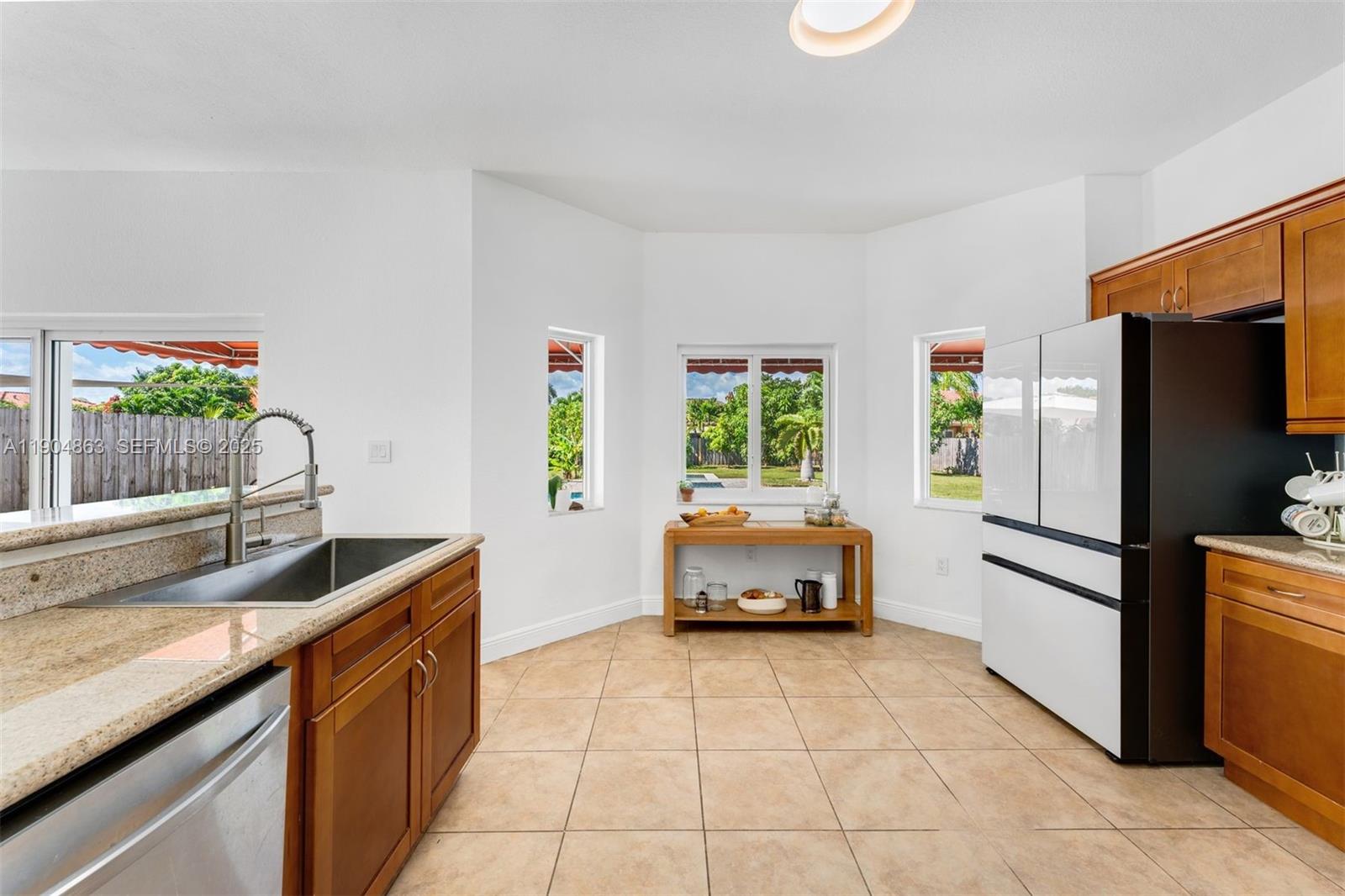 17080 Southwest 92nd Court Palmetto Bay, FL 33157 - Photo 13 of 40 a kitchen with stainless steel appliances granite countertop a refrigerator a stove a sink and a window