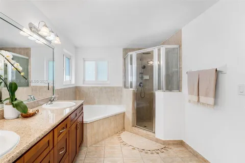 a spacious bathroom with a granite countertop sink a bathtub and shower