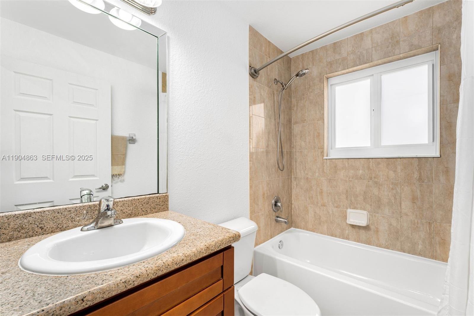 17080 Southwest 92nd Court Palmetto Bay, FL 33157 - Photo 31 of 40 a bathroom with a granite countertop sink toilet and shower