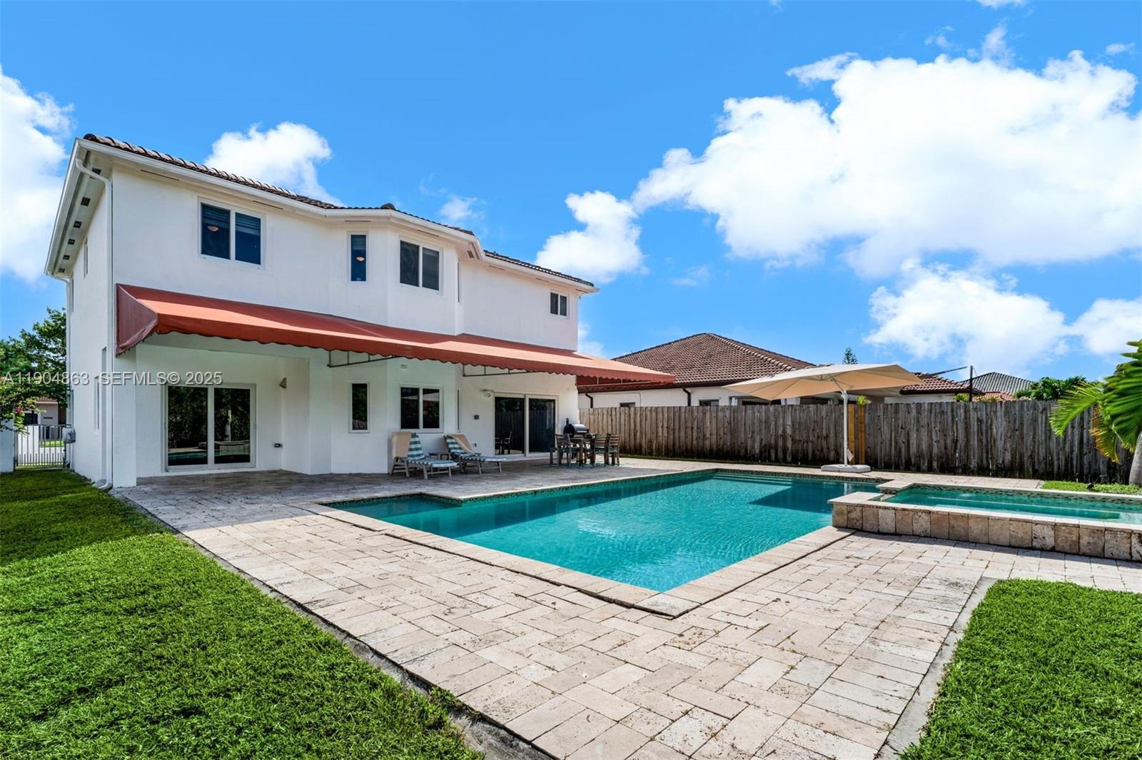 17080 Southwest 92nd Court Palmetto Bay, FL 33157 - Photo 35 of 40 a view of a white house with a big yard and potted plants and a big yard