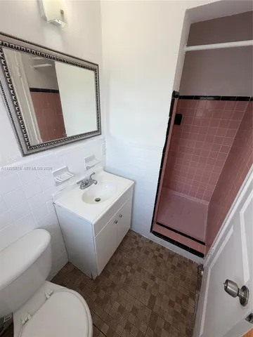 a bathroom with a toilet sink and mirror