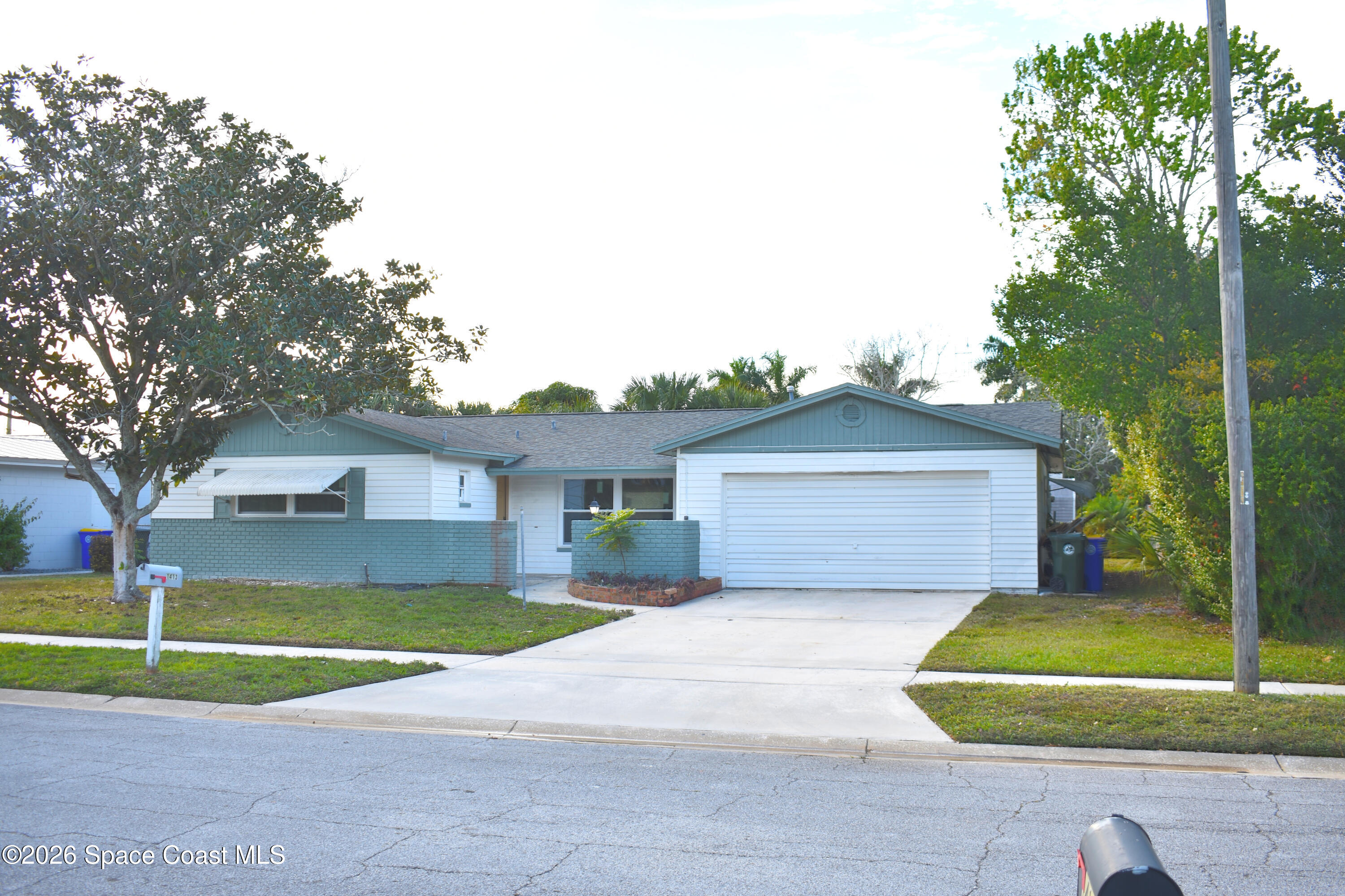 1413 Floyd Drive Rockledge, FL 32955 - Photo 2 of 17 a front view of a house with a yard and garage