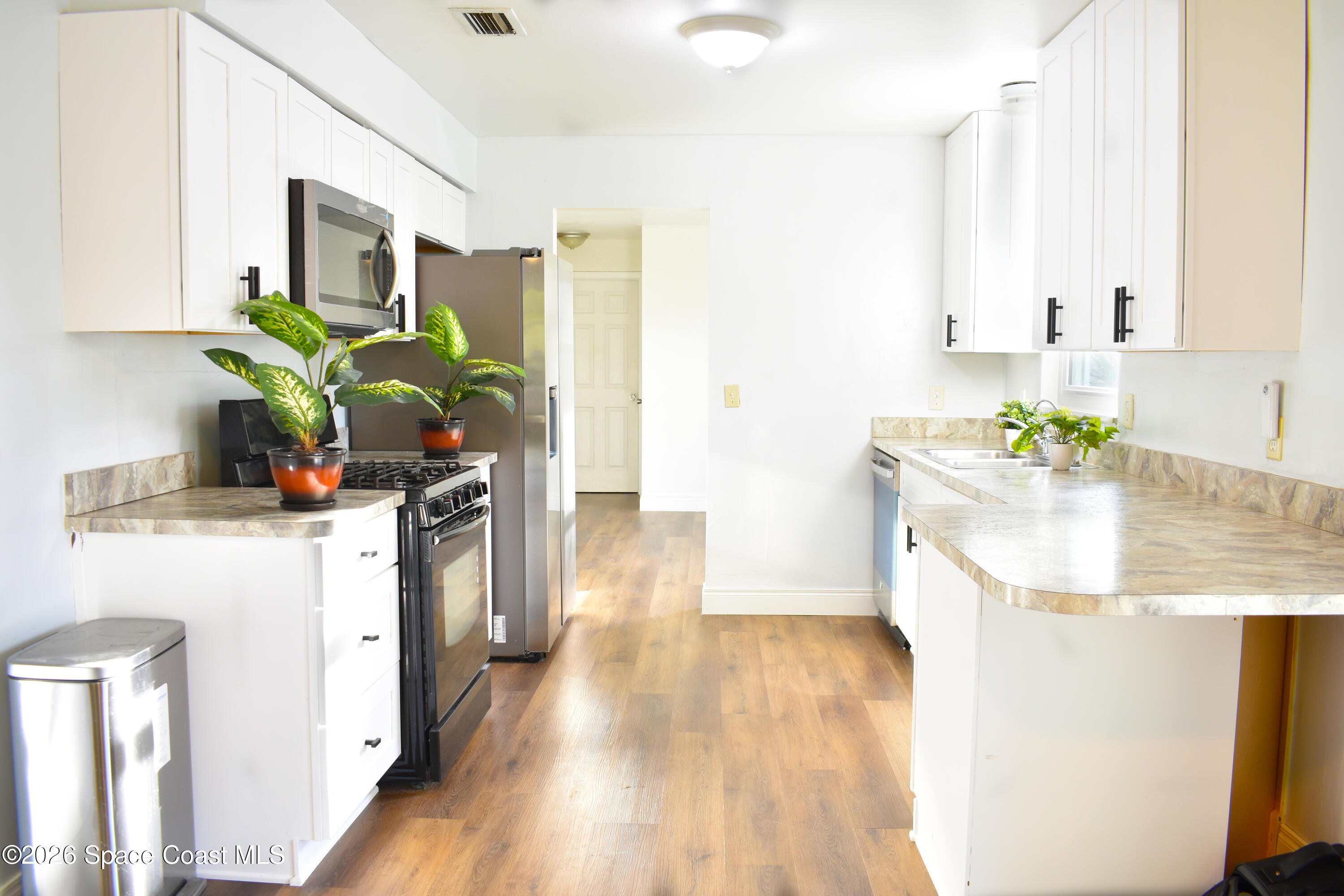 1413 Floyd Drive Rockledge, FL 32955 - Photo 3 of 17 a kitchen with a sink a counter top space and living room