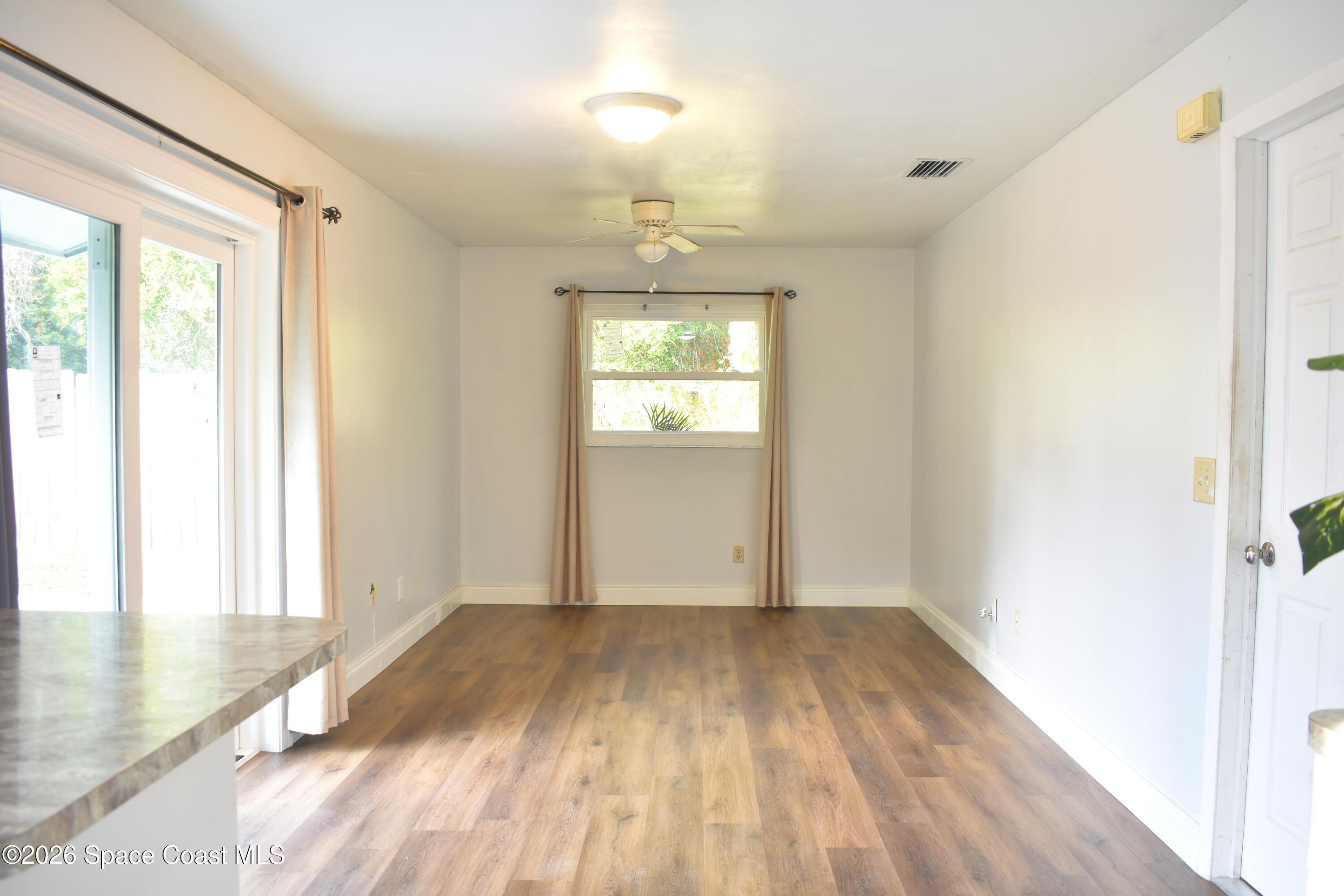 1413 Floyd Drive Rockledge, FL 32955 - Photo 6 of 17 a view of empty room with wooden floor and fan