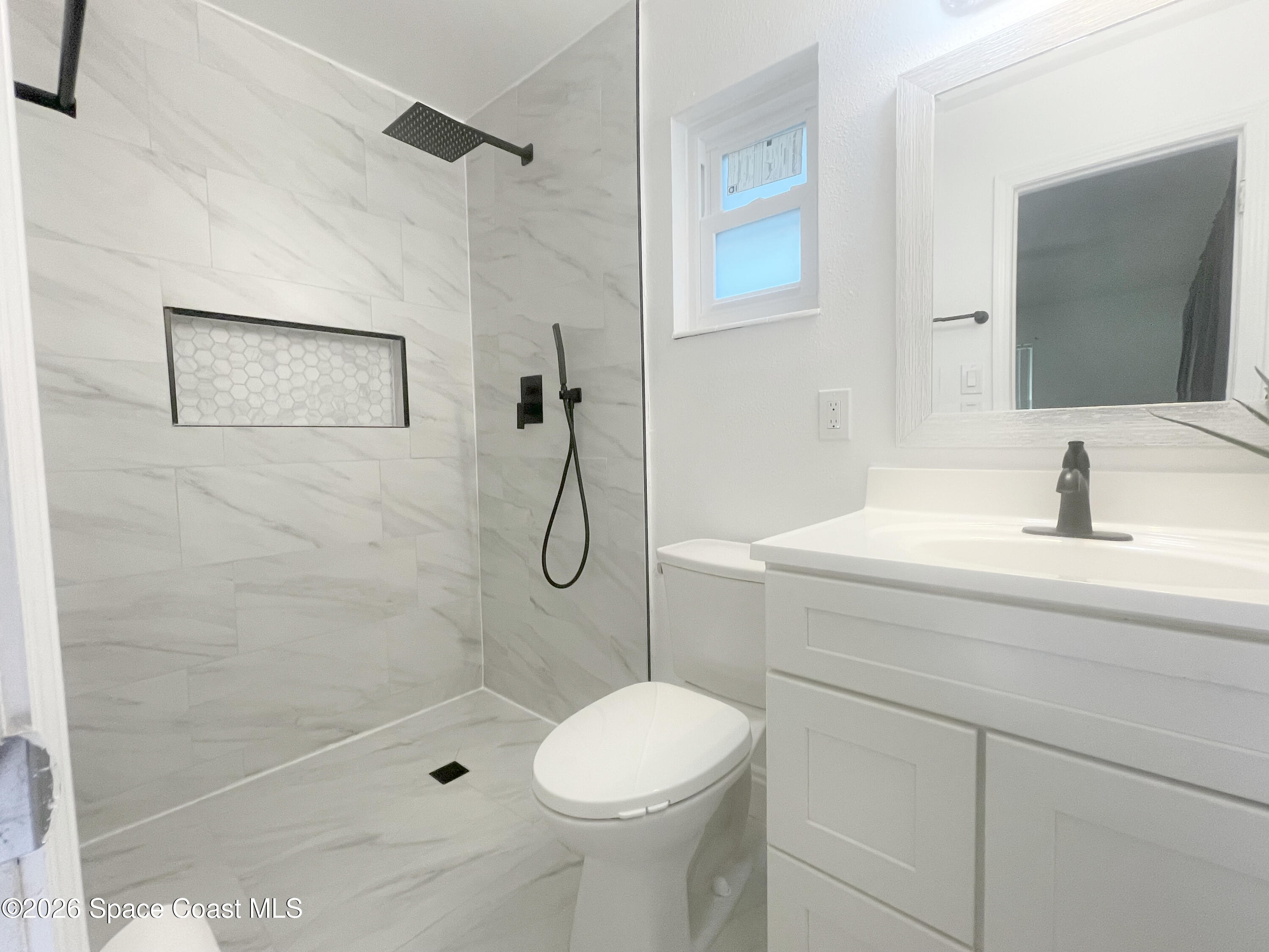 1413 Floyd Drive Rockledge, FL 32955 - Photo 7 of 17 a bathroom with a sink toilet and shower