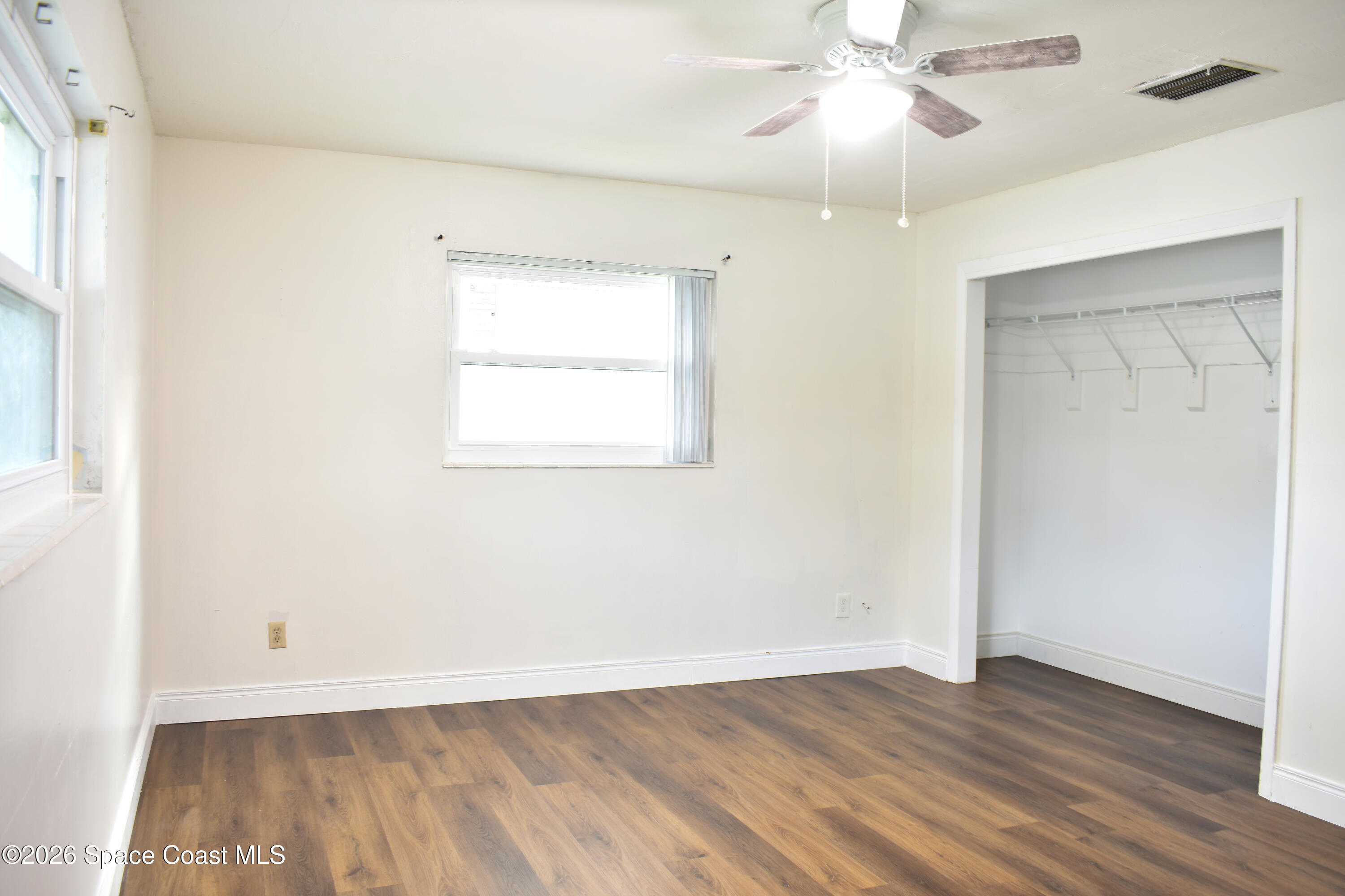 1413 Floyd Drive Rockledge, FL 32955 - Photo 9 of 17 wooden floor in an empty room with a window