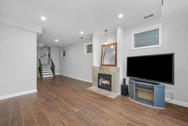 a view of a livingroom with a fireplace a flat screen tv and staircase
