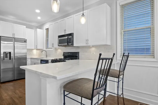 a view of kitchen with cabinets stainless steel appliances and a window