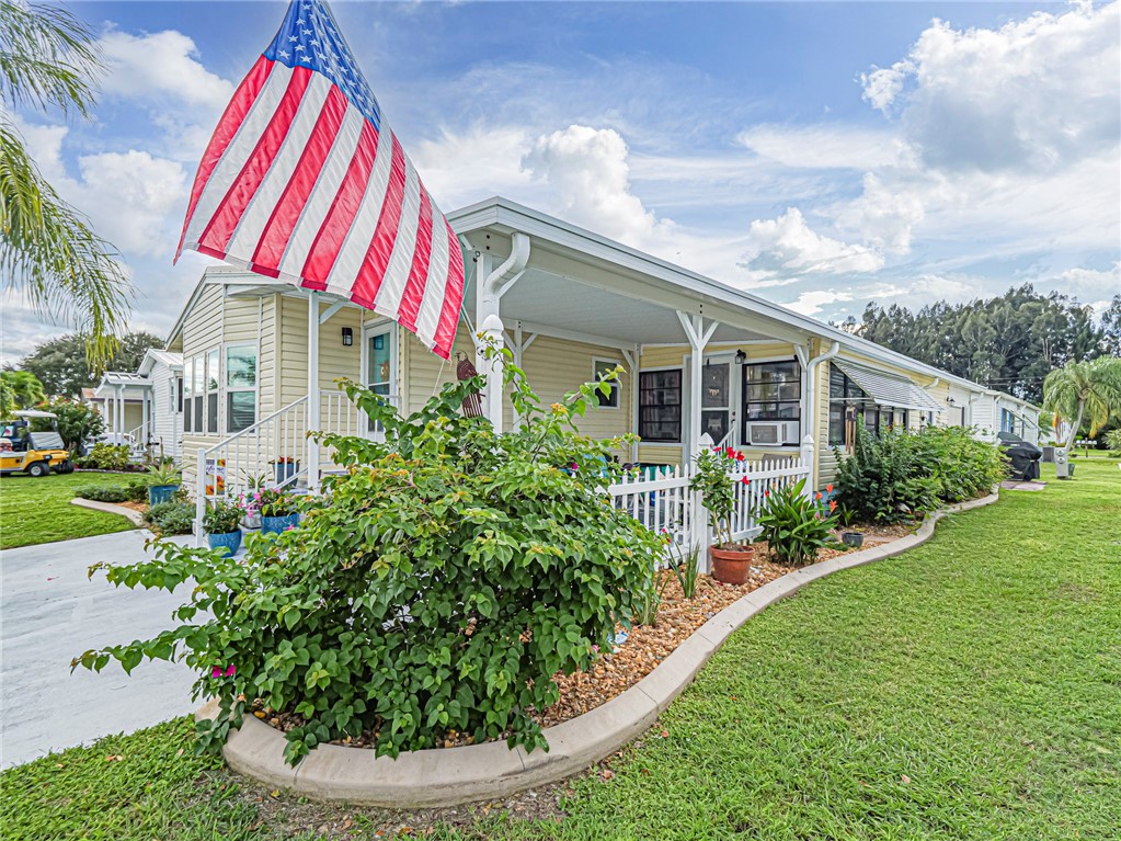 a front view of a house with a yard and potted plants