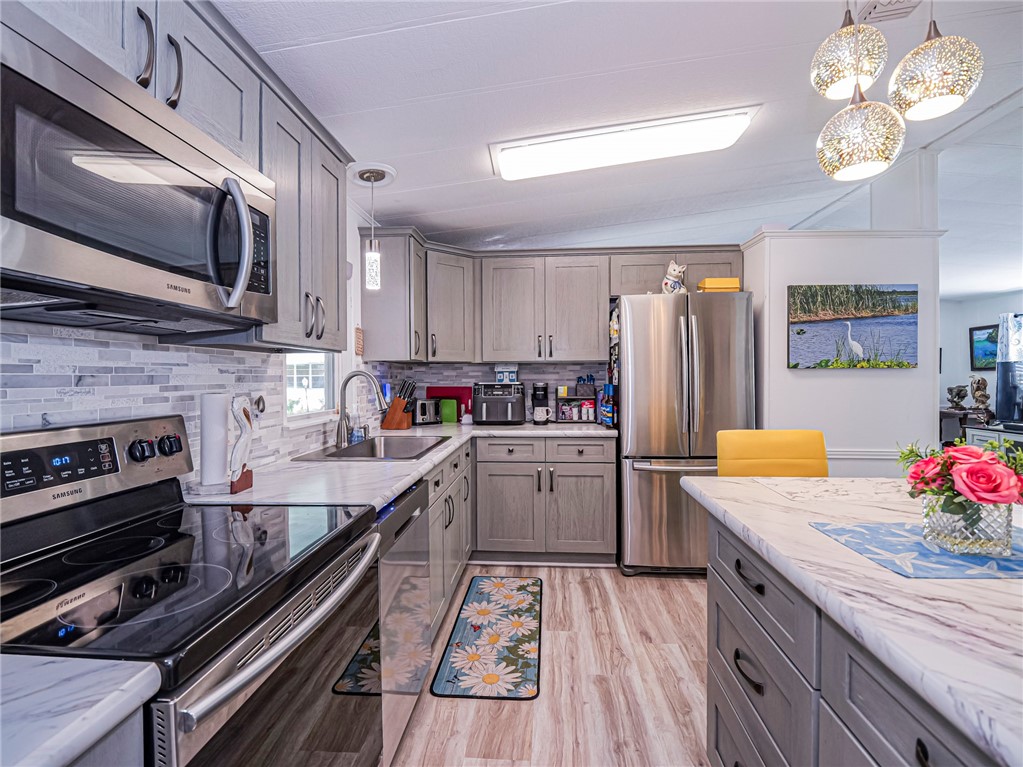 409 Avocado Drive Sebastian, FL 32976 - Photo 12 of 35 a kitchen with a sink stainless steel appliances and cabinets